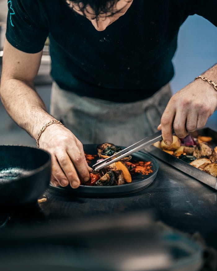 Chef skillfully preparing a gourmet meal in a modern kitchen setting.