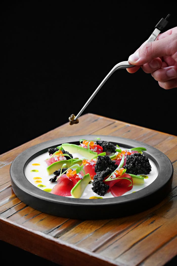 A gourmet dish being artfully prepared with tweezers. Captured in Lima, Peru.